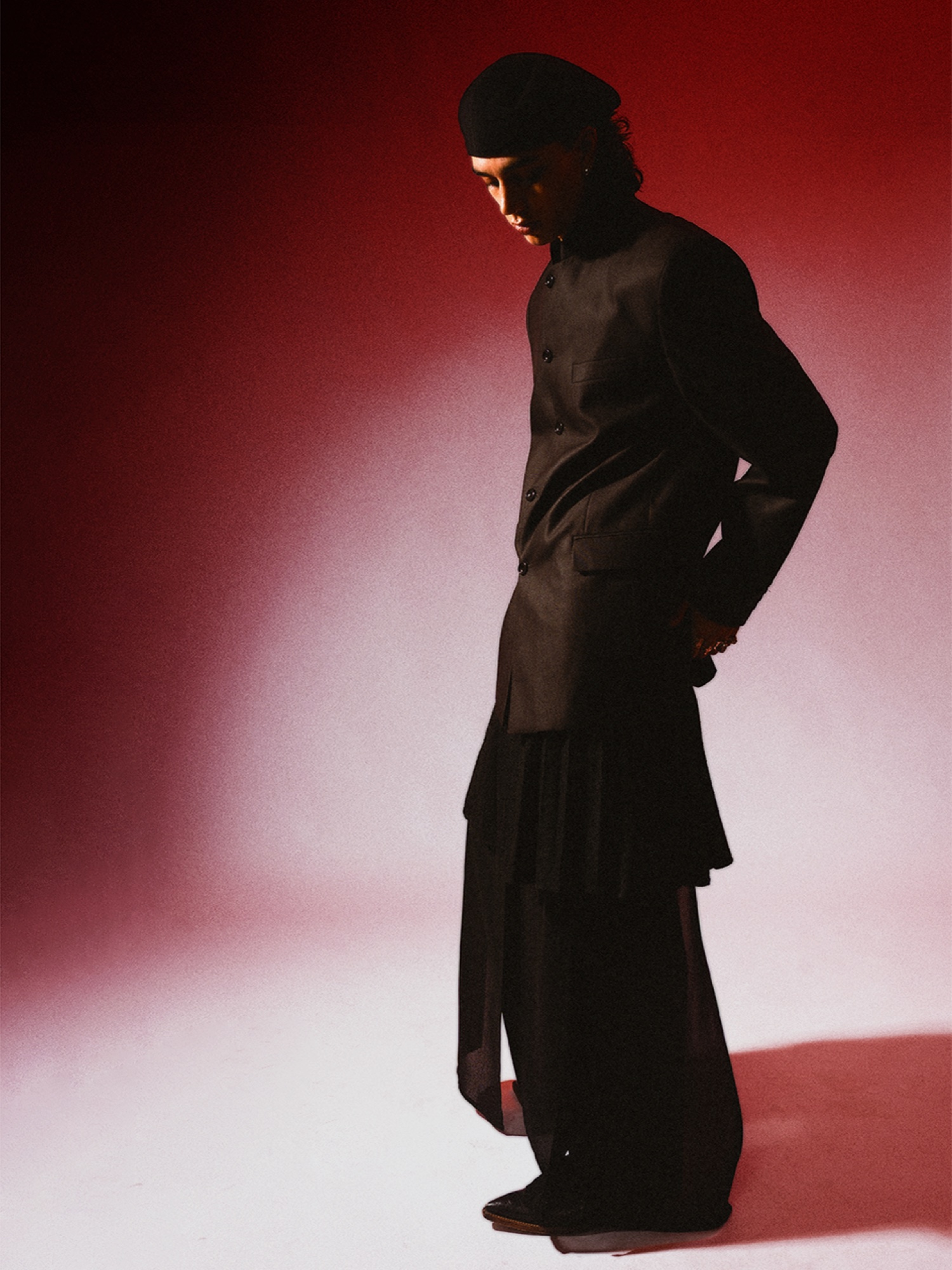 Full-length side portrait in black tailoring