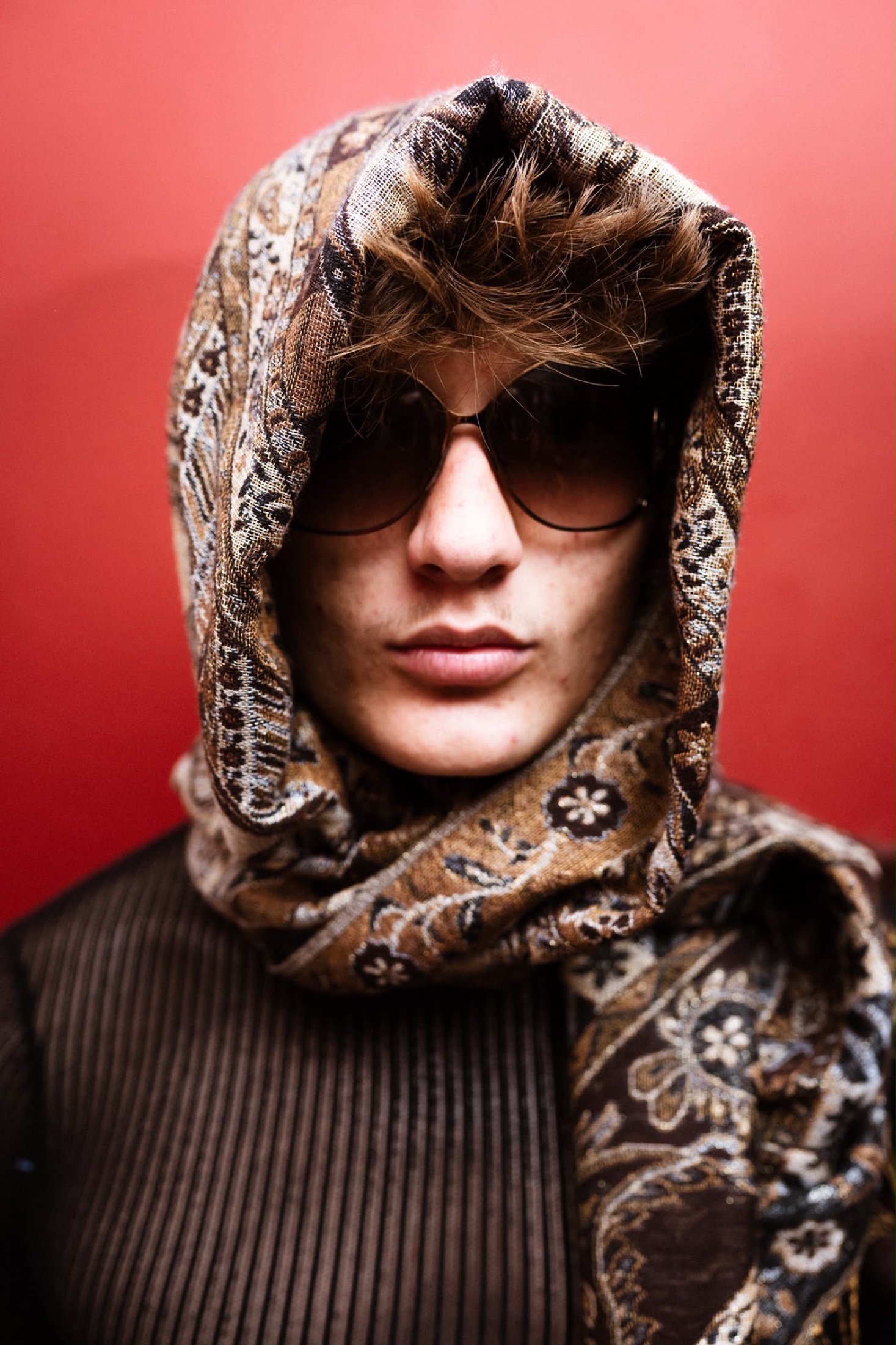 Portrait framed by a patterned scarf against red