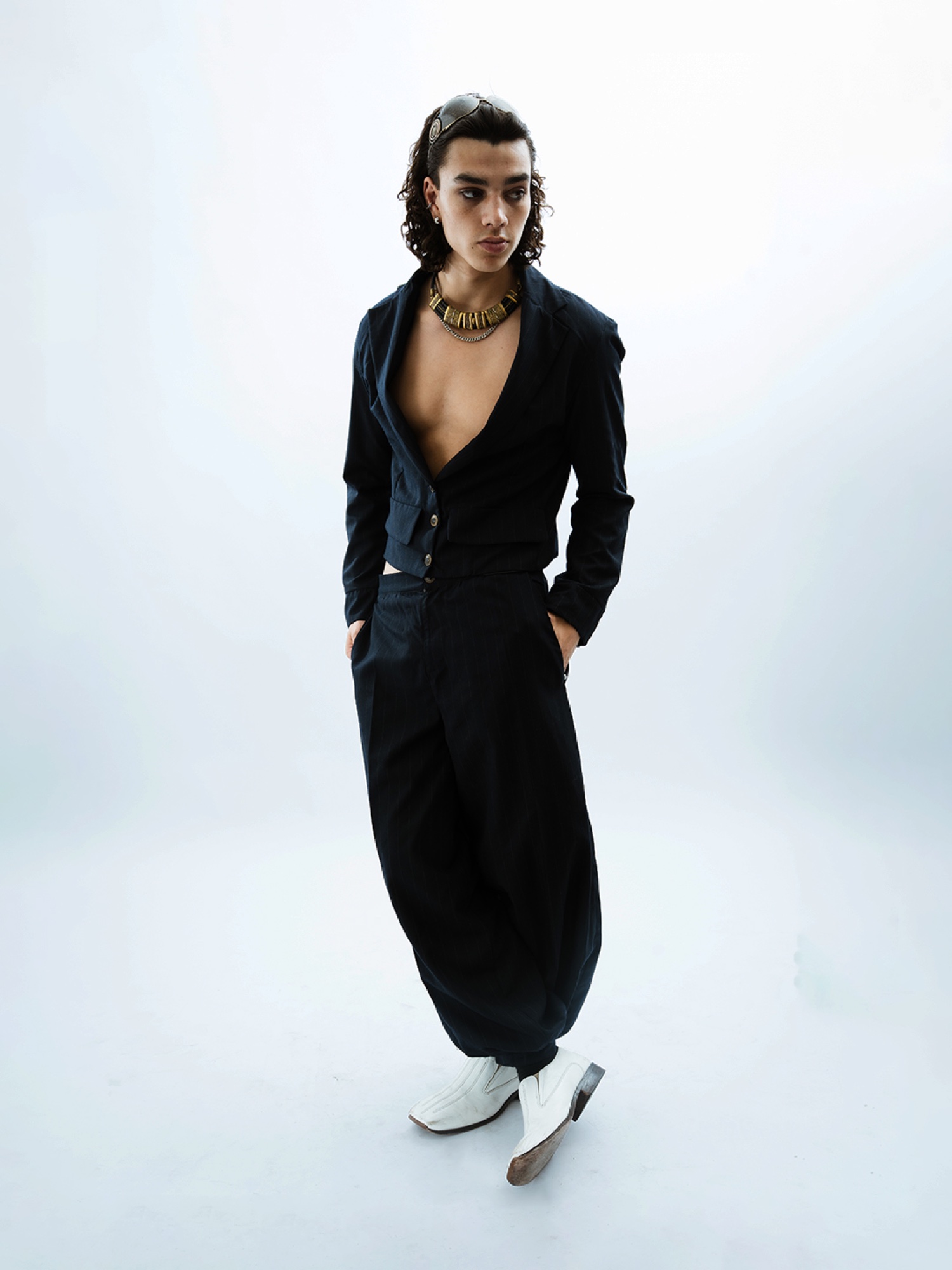 Model in a cropped black suit photographed on white
