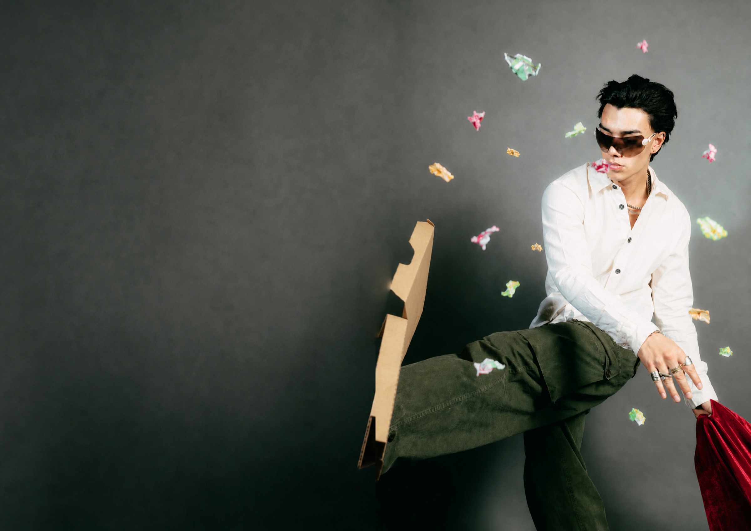 Figure in white shirt and dark trousers suspended among paper fragments