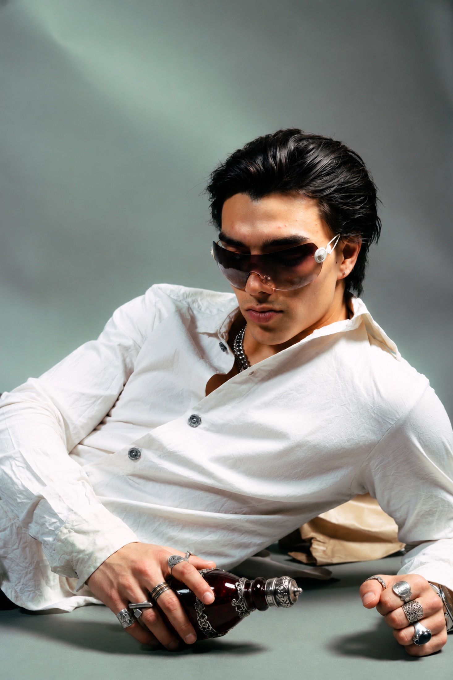 Reclining portrait holding an ornate glass bottle